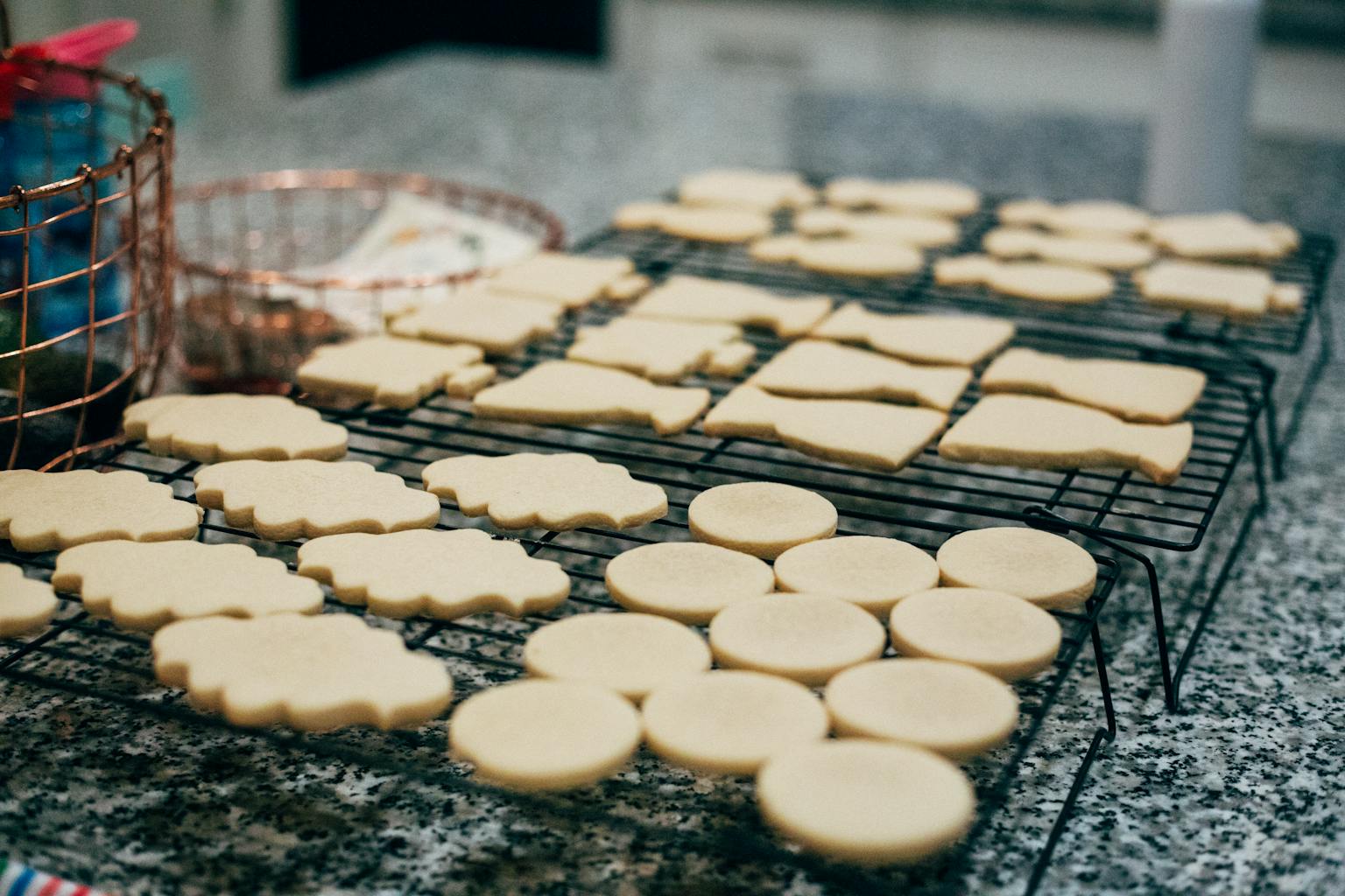 A batch of freshly baked cookies cooling on a wire rack in a home kitchen.